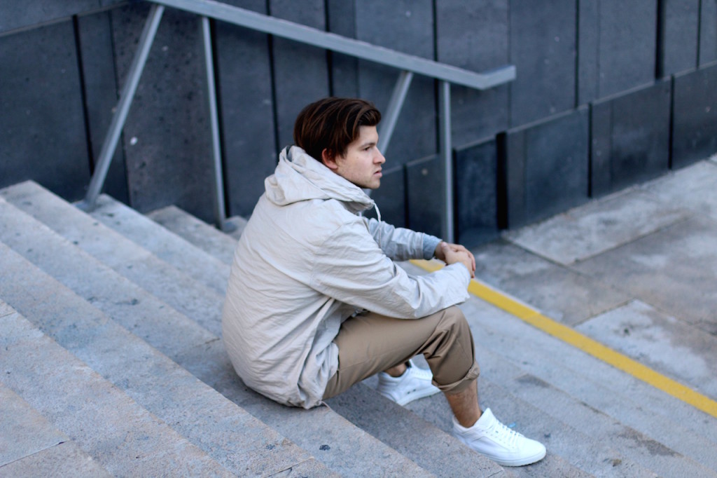 stylisch young men stands in front of concrete wall wearing H&M Studio SS16 Collection wide rolled up slacks in sandy beige tones with white sneakers a progressive spring outfit for the creative modern man spring/summer trends 2016